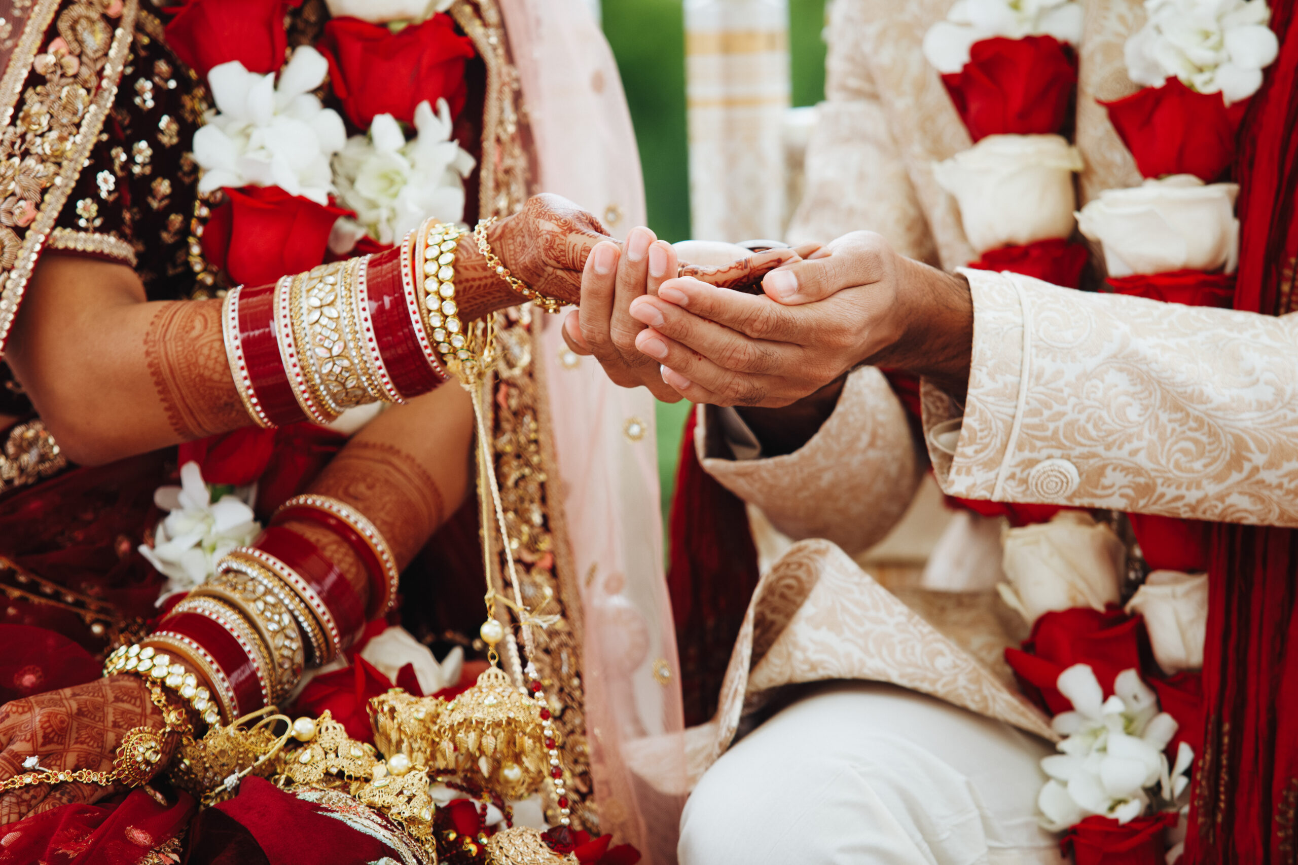 Hands of indian bride and groom intertwined together making authentic wedding ritual